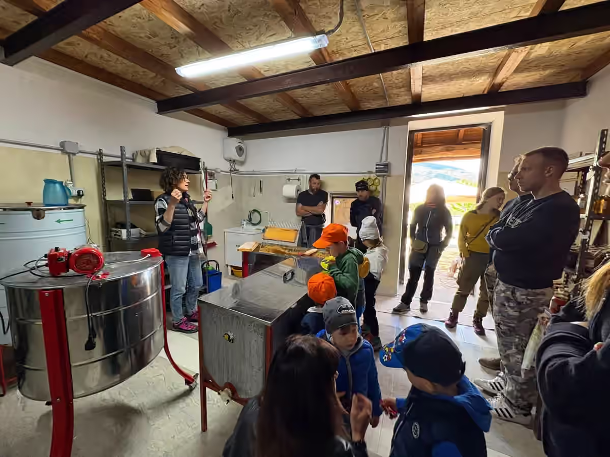 Bambini e adulti riuniti nel laboratorio dell’apiario