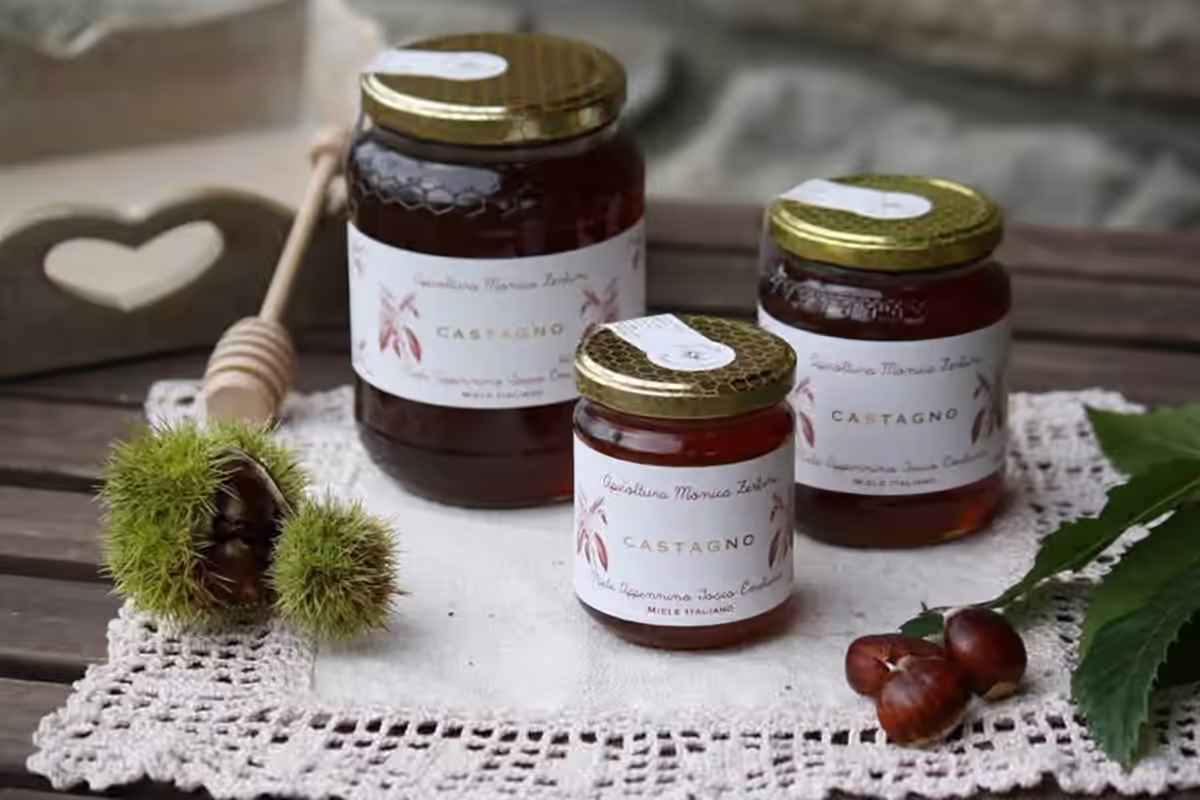 Vasetto di miele di castagno con ricci e foglie di castagno